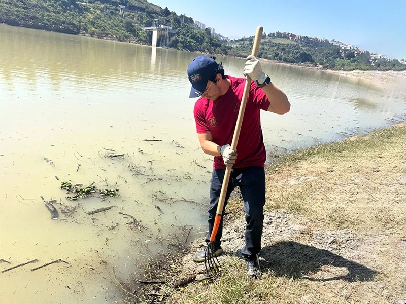 Joven limpia lago y forma parte del programa de responsabilidad social Humanitas